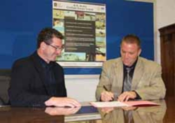 ERDC Cold Regions Research and Engineering Laboratory Deputy Director Dr. Lance Hansen (left) looks on as a Kearsarge, N.H., Regional School District's Assistant Superintendent Mark MacLean signs the Educational Partnership Agreement that provides many benefits to both the students and laboratory. 