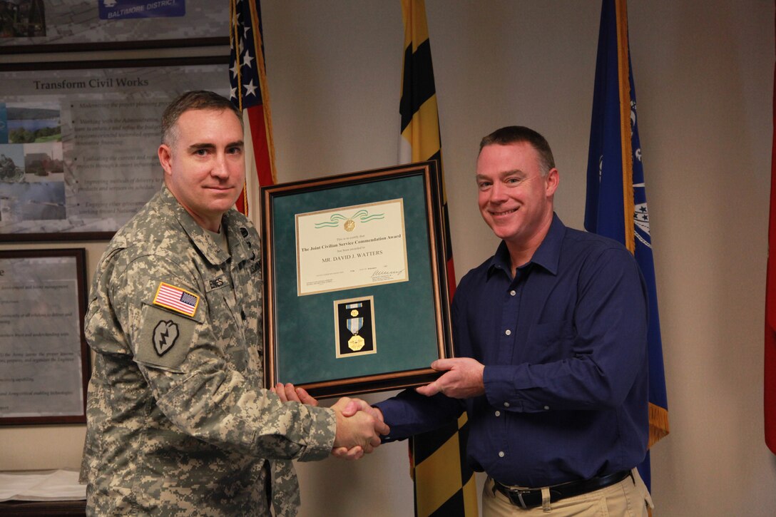 Lt. Col. Brad Endres, acting Baltimore District commander, presents the Joint Civilian Service Commendation Award to David Watters, senior health physicist.  Watters was recognized for his work on depleted uranium-related missions in Saudi Arabia and Kuwait.    