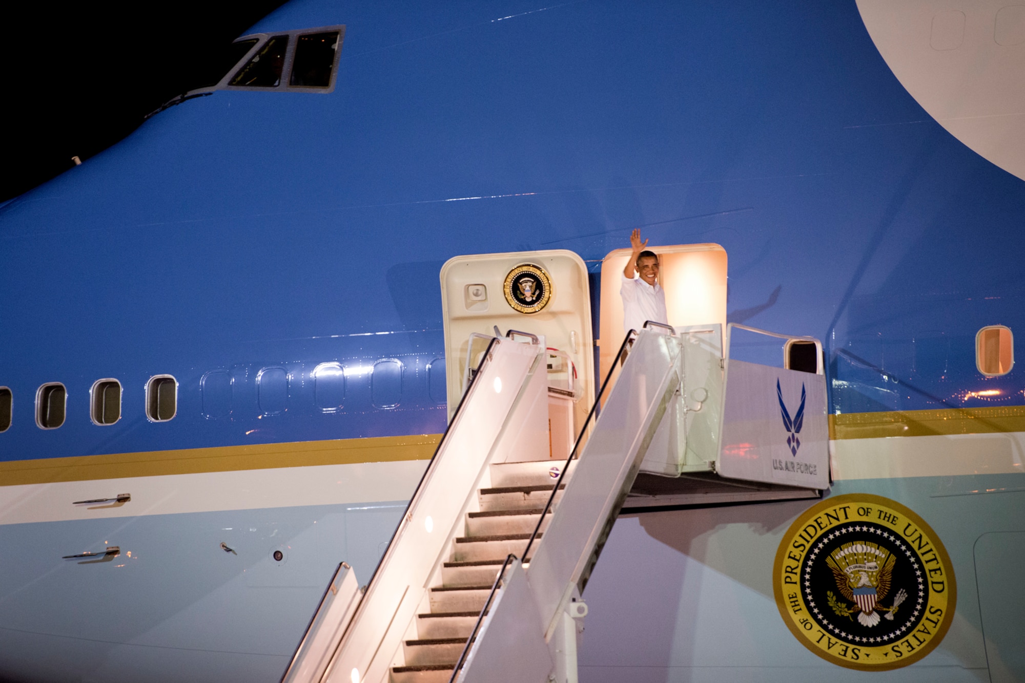 President Barack Obama waves to servicemembers and families at Hickam Field, Joint Base Pearl Harbor-Hickam, Hawaii, while boarding Air Force One, Dec. 26, 2012. After a brief vacation in Hawaii, President Obama is on his way back to Washington to address proposed extended tax cuts and looming fiscal cliff. He shook hands with a servicemembers and familes before boarding. (U.S. Air Force photo/Staff Sgt. Mike Meares)