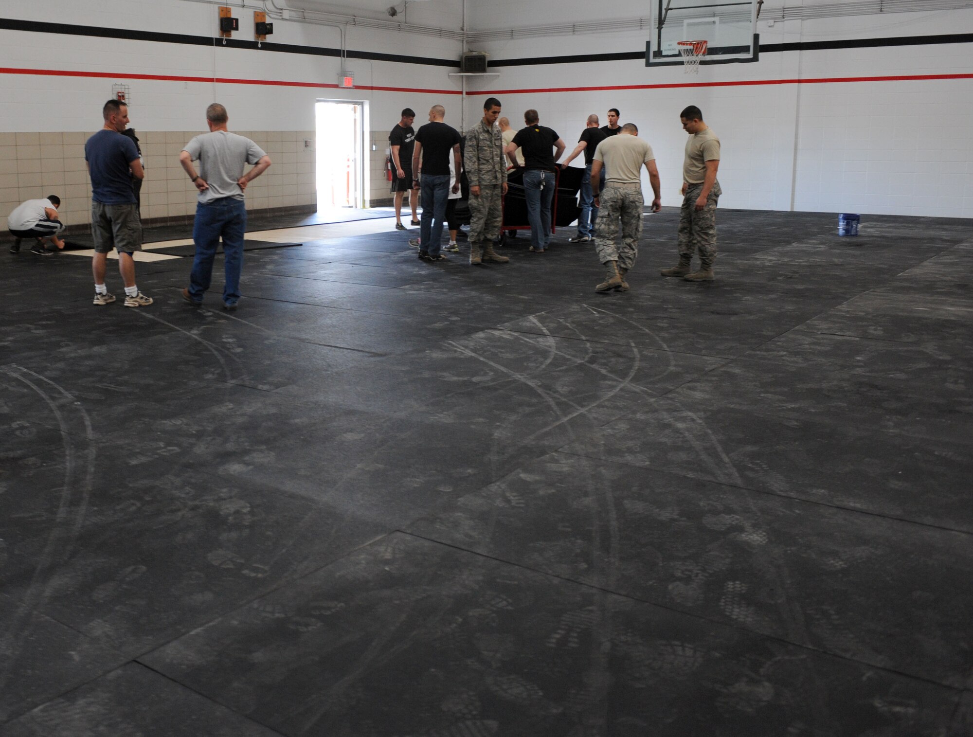 U.S. Air Force Airmen and U.S. Army Soldiers place the final mats down in the new cross functional fitness area in the Haeffner Fitness Center on Davis-Monthan Air Force Base, Ariz., Dec. 27, 2012. Once completed, the area will provide a proper facility and equipment for people new and experienced to cross fitness workouts. (U.S. Air Force photo by Senior Airman Timothy Moore/Released)