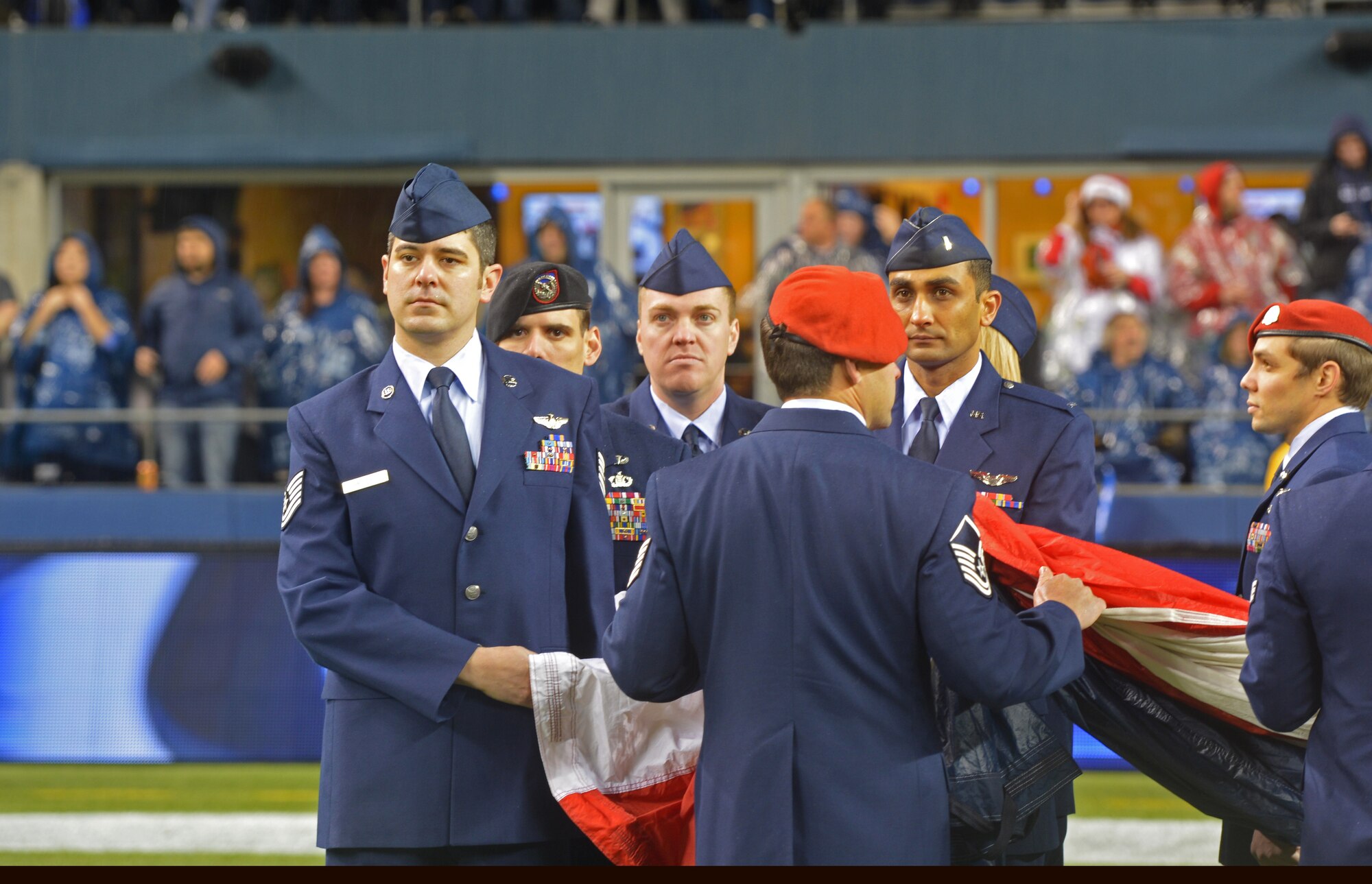 Tech. Sgt. Raymond Meyers (left) and 1st Lt. Amit Patel (2nd from the right), both from the 97th Airlift Squadron headquartered at McChord Field, hold the American flag with Airmen from the 62nd Airlift Wing and Western Air Defense Sector during the pre-game ceremony of the Seattle Seahawks- San Francisco 49ers National Football League game in Seattle, Wash., Dec. 23. The 446th Airlift Wing had 21 Reservists on the field. (U.S. Air Force Photo/Master Sgt. Todd Wivell)