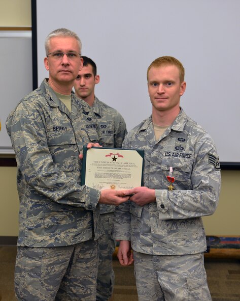Col. Bruce Beyerly, 1st Air Support Operations Group commander, presents a Bronze Star certificate to Staff Sgt. Andrew Cox, 5th Air Support Operations Squadron joint terminal attack controller, during a ceremony Dec. 21, 2012, at Joint Base Lewis-McChord, Wash. Cox led an understaffed 5-man team in conducting 91 airstrikes with zero civilian casualties during his deployment to Afghanistan. (U.S. Air Force photo/Staff Sgt. Jason Truskowski)