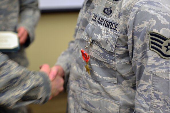Col. Bruce Beyerly, 1st Air Support Operations Group commander, awards Staff Sgt. Andrew Cox, 5th Air Support Operations Squadron joint terminal attack controller, the Bronze Star Medal during a ceremony Dec. 21, 2012, at Joint Base Lewis-McChord, Wash. Cox earned the medal for exceptional and meritorious service while deployed May through November 2011 in Afghanistan. (U.S. Air Force photo/Staff Sgt. Jason Truskowski)