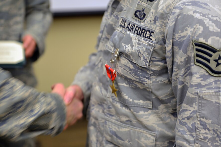 Col. Bruce Beyerly, 1st Air Support Operations Group commander, awards Staff Sgt. Andrew Cox, 5th Air Support Operations Squadron joint terminal attack controller, the Bronze Star Medal during a ceremony Dec. 21, 2012, at Joint Base Lewis-McChord, Wash. Cox earned the medal for exceptional and meritorious service while deployed May through November 2011 in Afghanistan. (U.S. Air Force photo/Staff Sgt. Jason Truskowski)