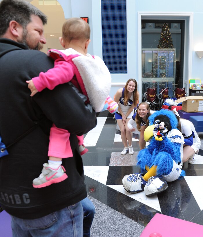 Falcon cheerleaders Barbara Terry, Elizabeth Kovarik and the Bird try to amuse a shy girl at the Cooks Children's Medical Center, while cheerleader Amanda Herman plays hide and go seek behind the Bird, during a visit by the Air Force Falcons football players and cheerleaders to the hospital in Fort Worth, Texas, Dec. 27, 2012. The Falcons traveled to Fort Worth for the 2012 Armed Forces Bowl. (U.S. Air Force photo/John Van Winkle)
