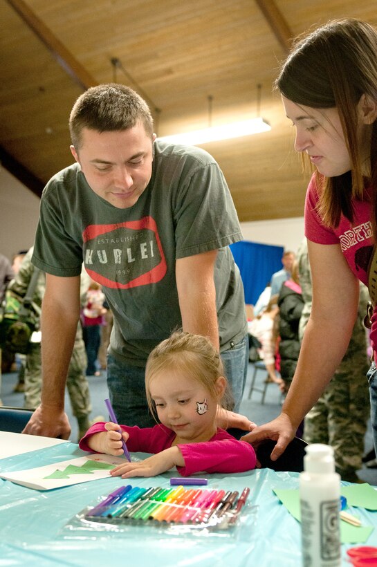 Staff Sgt. Jeremy Holland, a computer support specialist with the 123rd Communications Flight, watches with his wife, Amber Holland, as their daughter colors a Christmas tree during the 123rd Airlift Wing’s family holiday party at the Kentucky Air National Guard Base in Louisville, Ky., Dec. 2, 2012. The annual event also offered snacks and prizes for the more than 85 children who participated. (Kentucky Air National Guard photo by Staff Sgt. Maxwell Rechel)