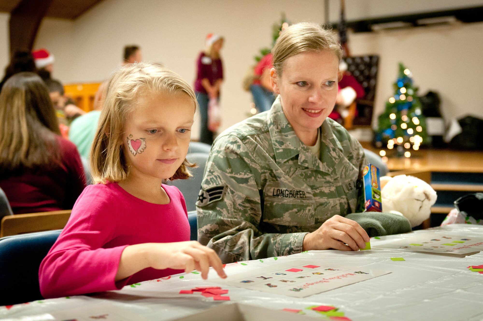 Staff Sgt. Melissa Longhofer, an orderly room administrator with the 123rd Aircraft Maintenance Squadron, plays bingo with her daughter during the 123rd Airlift Wing’s family holiday party at the Kentucky Air National Guard Base in Louisville, Ky., Dec. 2, 2012. The annual event also offered snacks and prizes for the more than 85 children who participated. (Kentucky Air National Guard photo by Staff Sgt. Maxwell Rechel)