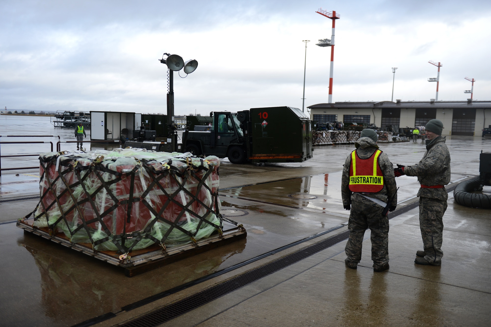 SPANGDAHLEM AIR BASE, Germany – U.S. Air Force Senior Airman Jonathan Loew, 52nd Logistics Readiness Squadron fuels hydrant from Palmer, Alaska, left, and Senior Airman Coleman Haynes, 480th Aircraft Maintenance Squadron hazardous equipment specialist from Nevis, Minn., discuss the placement of cargo on the flightline Dec. 27, 2012. Cargo containers are organized in the order they will be packed on the plane to expedite the process. The cargo will accompany the 480th Fighter Squadron to Nellis Air Force Base for Red Flag, an advanced aerial combat training exercise. (U.S. Air Force photo by Airman 1st Class Gustavo Castillo/Released)