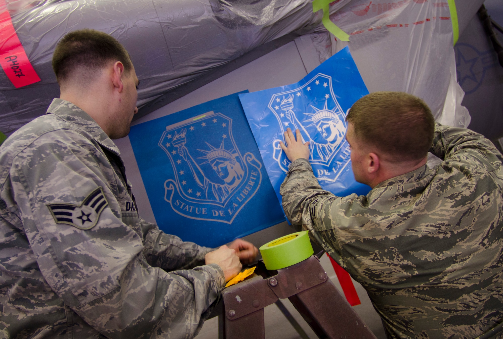 ROYAL AIR FORCE LAKENHEATH, England - Senior Airman Chris Dalton (left), 48th Equipment Maintenance Squadron aircraft structural journeyman and native of Astoria, Ore., and Airman 1st Class Joel Marbury, 48th EMS aircraft structural journeyman and native of Carpentersville, Ill., compare a Liberty Wing patch stencil on an F-15C Eagle to a template Dec. 18, 2012. The 48th EMS corrosion control section is responsible for ensuring all Liberty Wing aircraft and associated equipment are corrosion free and painted. (U.S. Air Force photo by Staff Sgt. Stephen Linch)