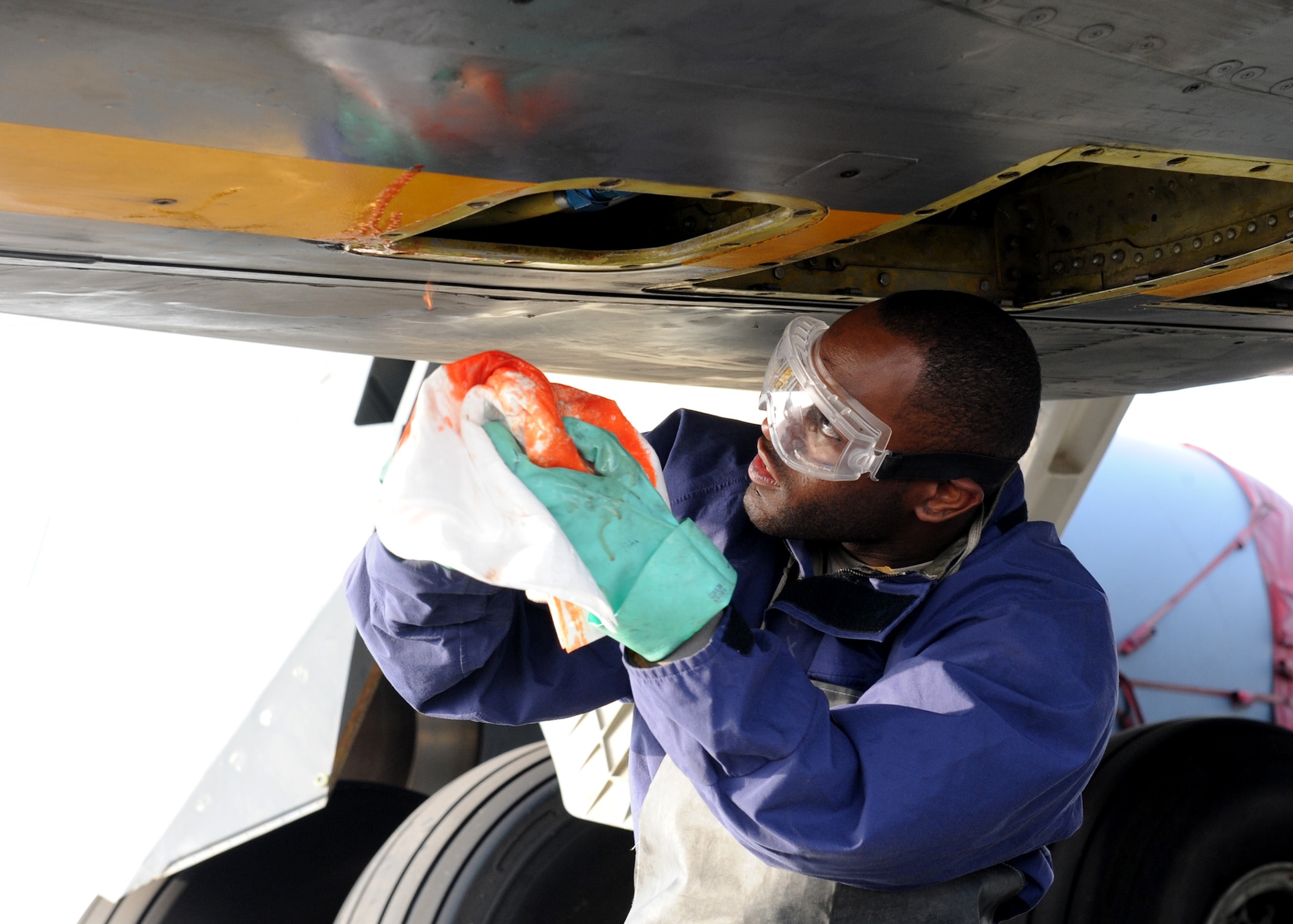 SOUTHWEST ASIA - Senior Airman Quardarrius Fitts, 379th Expeditionary Maintenance Squadron fuel systems journeyman, uses a towel to catch loose hydraulics fuel after taking off a valve on a KC-135 Dec. 26. Fitts is deployed from the 6th Maintenance Squadron at MacDill Air Force Base, Fla., and is a native of Stone Mountain, Ga. (U.S. Air Force photo/Senior Airman Joel Mease)