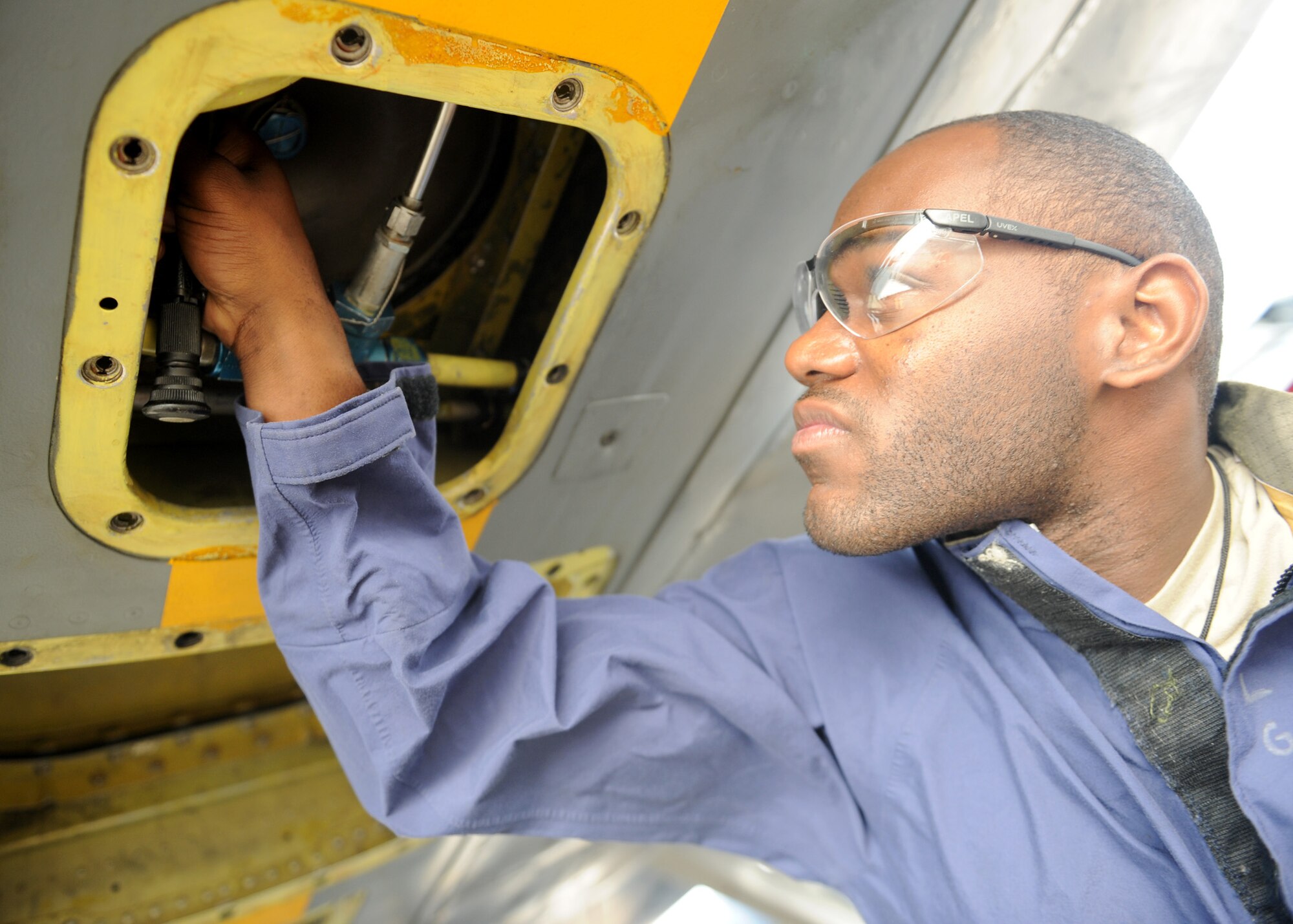 SOUTHWEST ASIA - Senior Airman Quardarrius Fitts, 379th Expeditionary Maintenance Squadron fuel systems journeyman, works to remove a stubborn valve that is causing a hydraulics leak on a KC-135 Dec. 26. Fitts is deployed from the 6th Maintenance Squadron at MacDill Air Force Base, Fla., and is a native of Stone Mountain, Ga. (U.S. Air Force photo/Senior Airman Joel Mease)