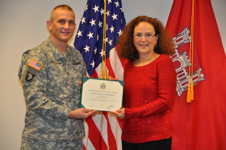 Col. Jon Christensen presents Darralyn Williams with a Certificate of Retirement at her retirement ceremony on Dec. 20. 