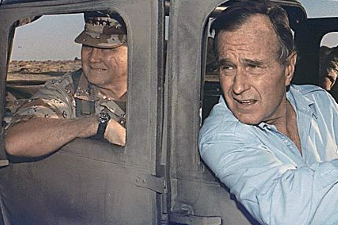 President George H.W. Bush, front, rides in a Humvee with with U.S. Army Gen. H. Norman Schwarzkopf, commander of U.S. Central Command, during a visti to  troops in Saudi Arabia on Thanksgiving Day, Nov. 22, 1990. 
