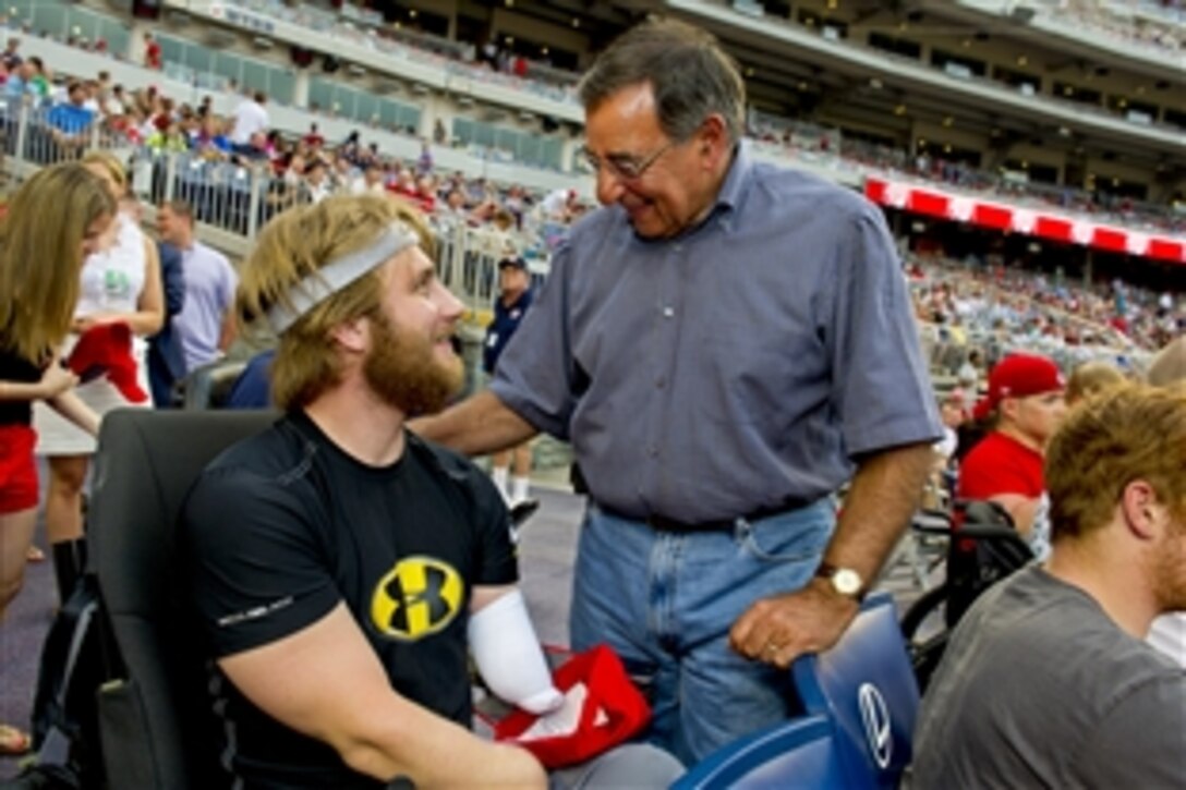 Defense Secretary Leon E. Panetta speaks to a wounded warrior from Walter Reed National Military Medical Center during a Washington Nationals baseball game in Washington, D.C., July 18, 2012.