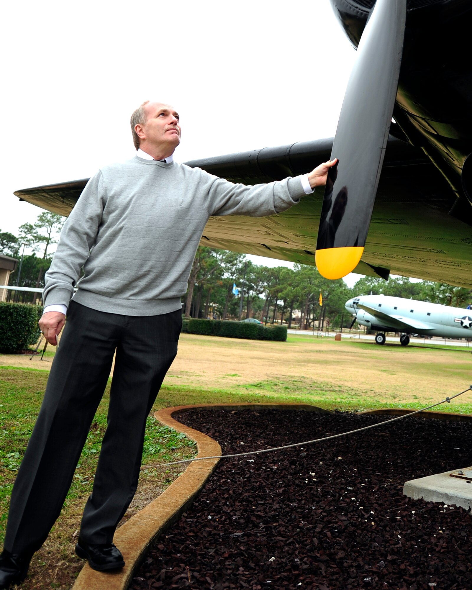Kim Carmean touches the rotor wing of a C-47 Sky Train, the plane his late father - Army Air Force Tech Sgt. Cletis Carmean used to work on, during a visit to the Air Park on Hurlburt Field, Fla., Dec. 28, 2012. Cletis, a former Airman with the 316th Troop Carrier Group based out of Hurlburt Field, served as a crew chief for the same plane during the paratrooper drops and reinforcements missions in the Invasion of Normandy during World War II, June 1944. (U.S. Air Force photo by Senior Airman Kentavist Brackin)
