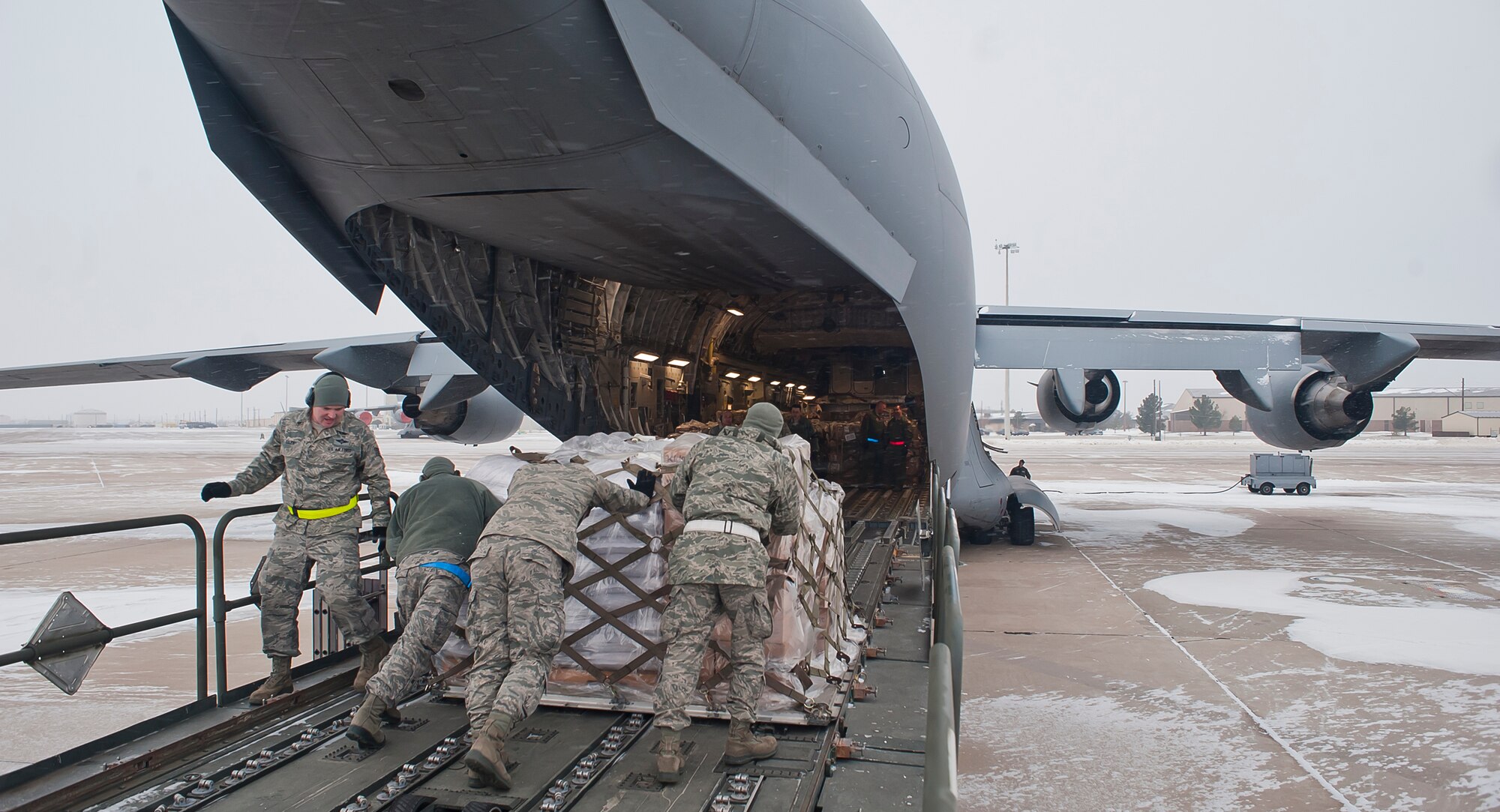 ALTUS AIR FORCE BASE, Okla. – 97th Logistics Readiness Squadron air operations flight members push a pallet loaded with food into the back of a C-17 Globemaster III, Dec. 28, 2012. After loading 137,000 pounds of beans and rice, members of the 58th Airlift Squadron transported the food to Port-au-Prince, Haiti in support of the Denton Amendment, a program that provides relief to Haitian citizens by making the transportation of humanitarian aid possible. The goods transported to Haiti were donated by Operation Ukraine, a nonprofit organization that provides relief to Haitian citizens with food, medicine, and school supplies. (U.S. Air Force photo by Airman 1st Class Levin Boland / Released)