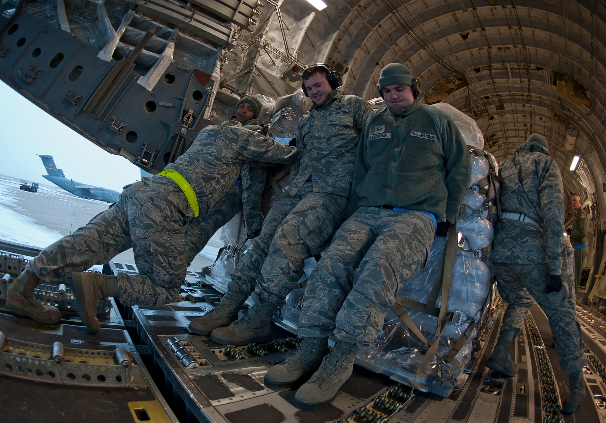 ALTUS AIR FORCE BASE, Okla. – 97th Logistics Readiness Squadron aerial operations flight members push a pallet loaded with food into the back of a C-17 Globemaster III, Dec. 28, 2012. The 58th Airlift Squadron transported the food to Port-au-Prince, Haiti to provide relief by helping feed Haitian children. (U.S. Air Force photo by Airman 1st Class Levin Boland / Released)
