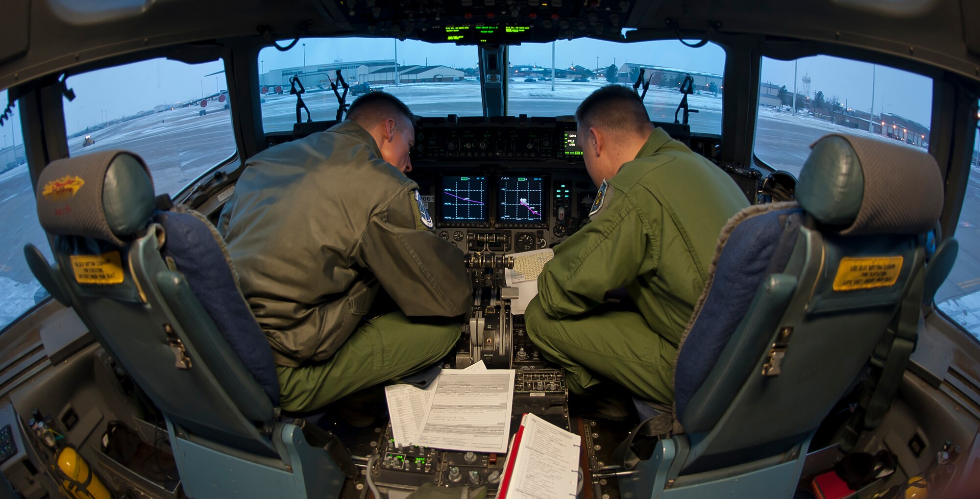ALTUS AIR FORCE BASE, Okla. – Maj. Jody Turk, 730th Air Mobility Training Squadron assistant director of operations, and Maj. Bryan Bailey, 730th AMTS C-17 Globemaster III flight commander, review a pre-flight checklist in the cockpit of a C-17 Globemaster III, Dec. 28, 2012. The pilots were preparing to transport 137,000 pounds of food to Port-au-Prince, Haiti, where it will be used to feed Haitian children. (U.S. Air Force photo by Airman 1st Class Levin Boland / Released)