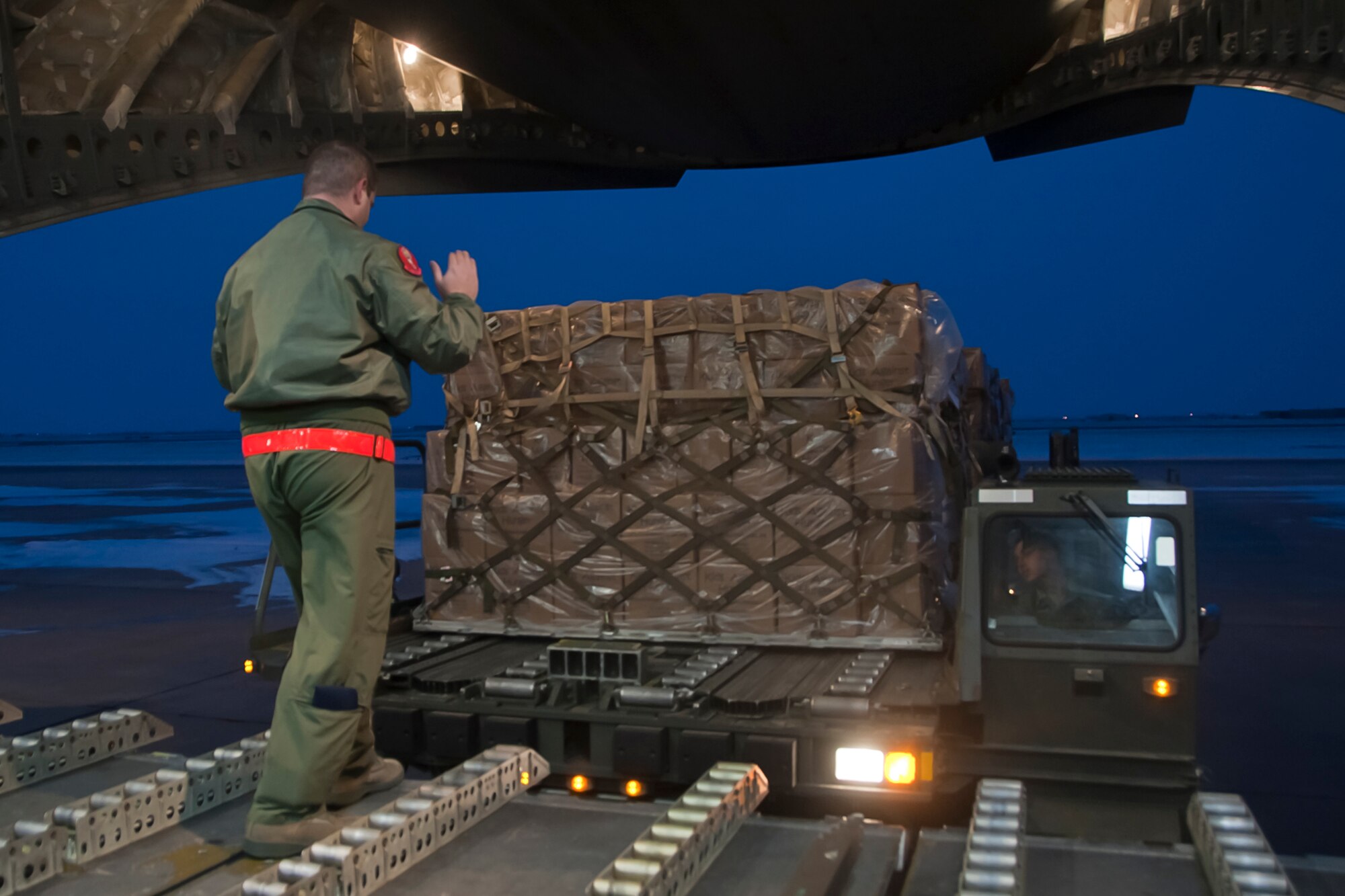 ALTUS AIR FORCE BASE, Okla. – Staff Sgt. Brian Derosa, 58th Airlift Squadron loadmaster instructor, directs a K-loader into the back of a C-17 Globemaster III, Dec. 28, 2012. 137,000 pounds of food was transported to Port-au-Prince, Haiti in support of the Denton Amendment, a program that provides relief to Haitian citizens by making the transportation of humanitarian aid possible. The goods transported to Haiti were donated by Operation Ukraine, a nonprofit organization that provides relief to Haitian citizens with food, medicine, and school supplies. (U.S. Air Force photo by Airman 1st Class Levin Boland / Released)