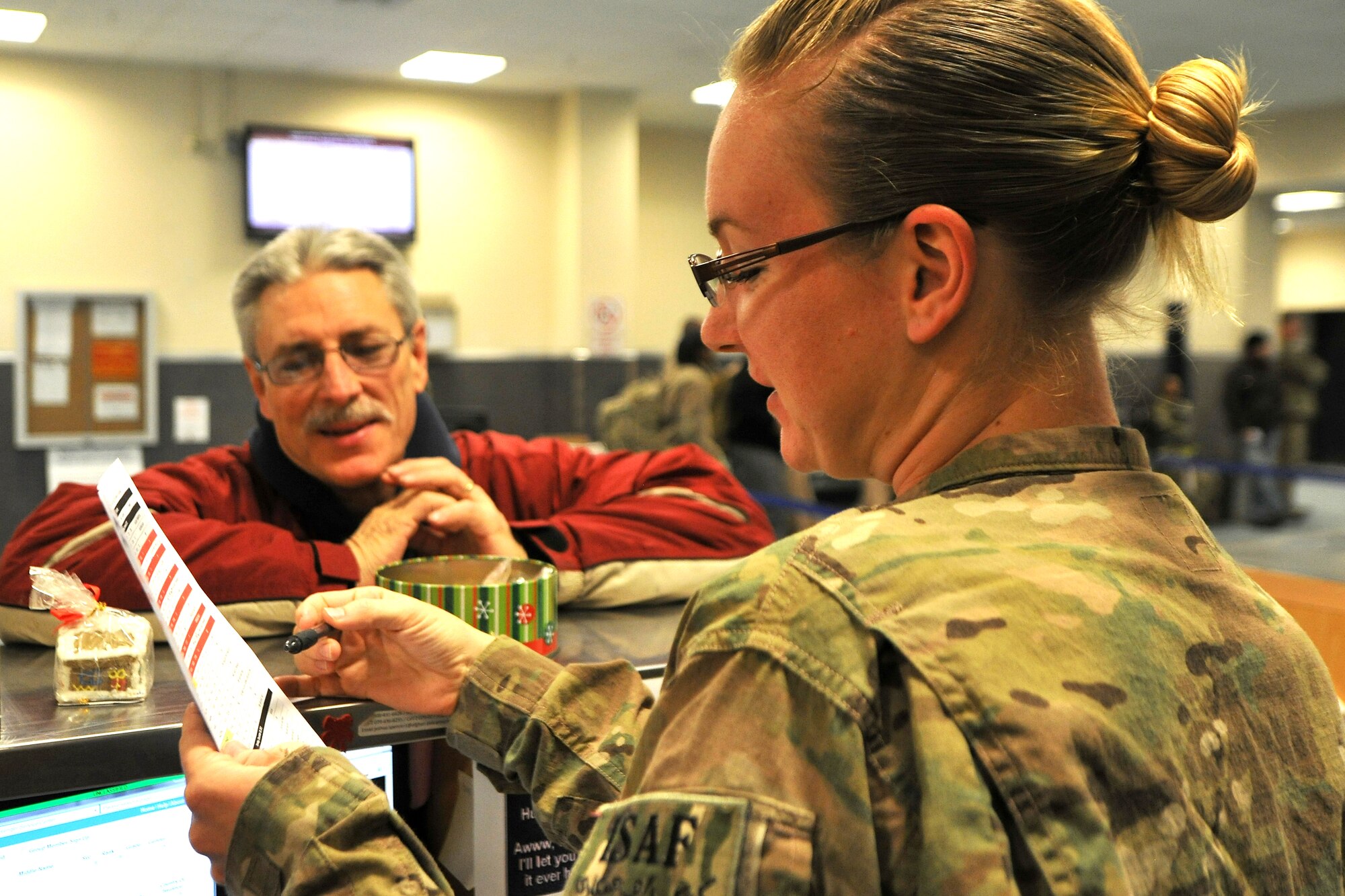 Staff Sgt.  Genie Spencer, 455th Expeditionary Aerial Port Squadron passenger services agent, goes over a passenger’s space-available flight plan at Bagram Airfield, Afghanistan, Dec. 29, 2012.  The terms space-available and space-required are used interchangeably in Afghanistan, as all passengers without a unit line number assigning them to a specific aircraft can only check in to travel to a specific destination. (U.S. Air Force photo/Senior Airman Chris Willis)