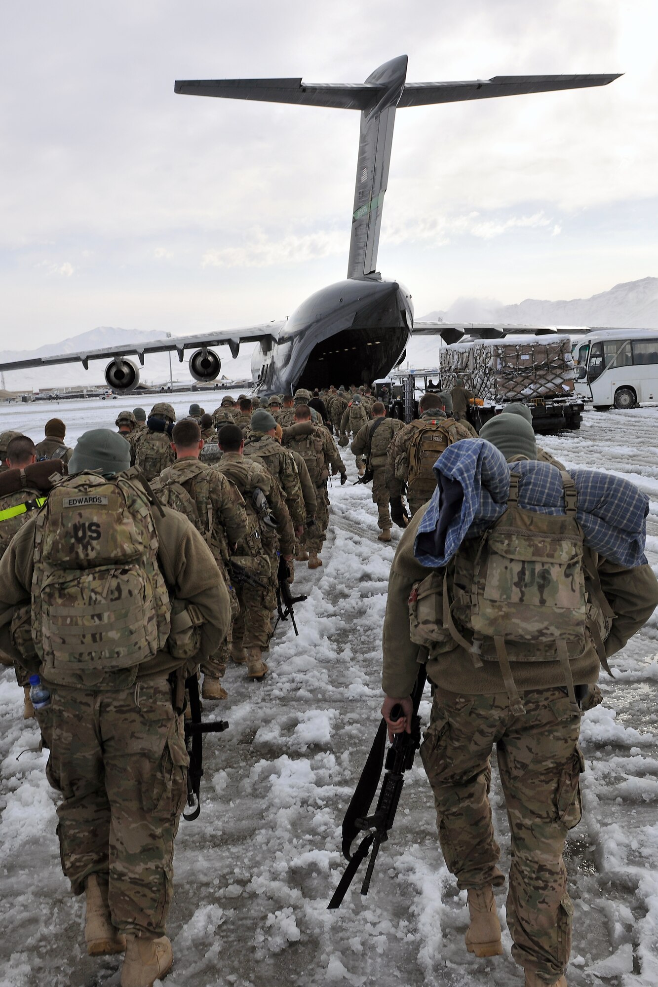 Servicemembers board a U.S. Air Force C-17 Globemaster III at Bagram Airfield, Afghanistan, Dec. 28, 2012.  The airfield management office coordinated snow removal and clearing to keep operations flowing after an overnight snowfall covered the flightline with more than three inches of snow. (U.S. Air Force photo/Senior Airman Chris Willis)