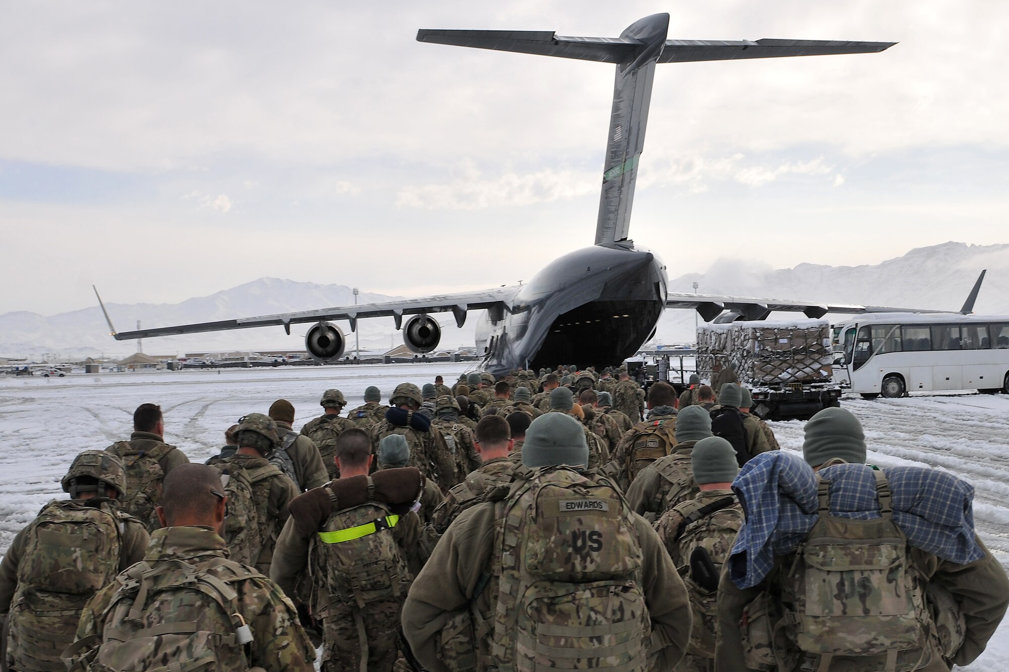 Servicemembers board a U.S. Air Force C-17 Globemaster III at Bagram Airfield, Afghanistan, Dec. 28, 2012.  The airfield management office coordinated snow removal and clearing to keep operations flowing after an overnight snowfall covered the flightline with more than three inches of snow. (U.S. Air Force photo/Senior Airman Chris Willis)