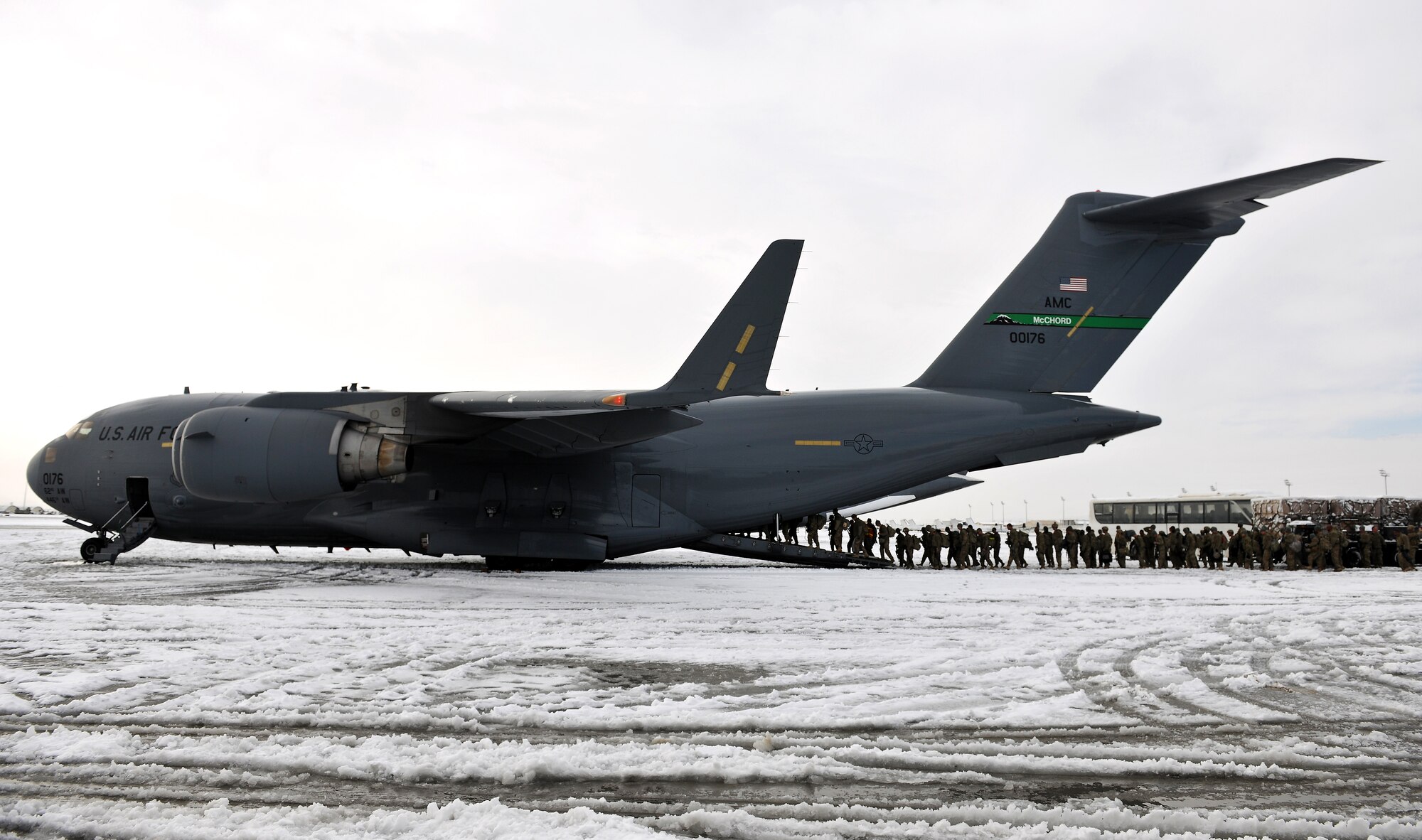 Servicemembers board a U.S. Air Force C-17 Globemaster III at Bagram Airfield, Afghanistan, Dec. 28, 2012.  The airfield management office coordinated snow removal and clearing to keep operations flowing after an overnight snowfall covered the flightline with more than three inches of snow. (U.S. Air Force photo/Senior Airman Chris Willis)