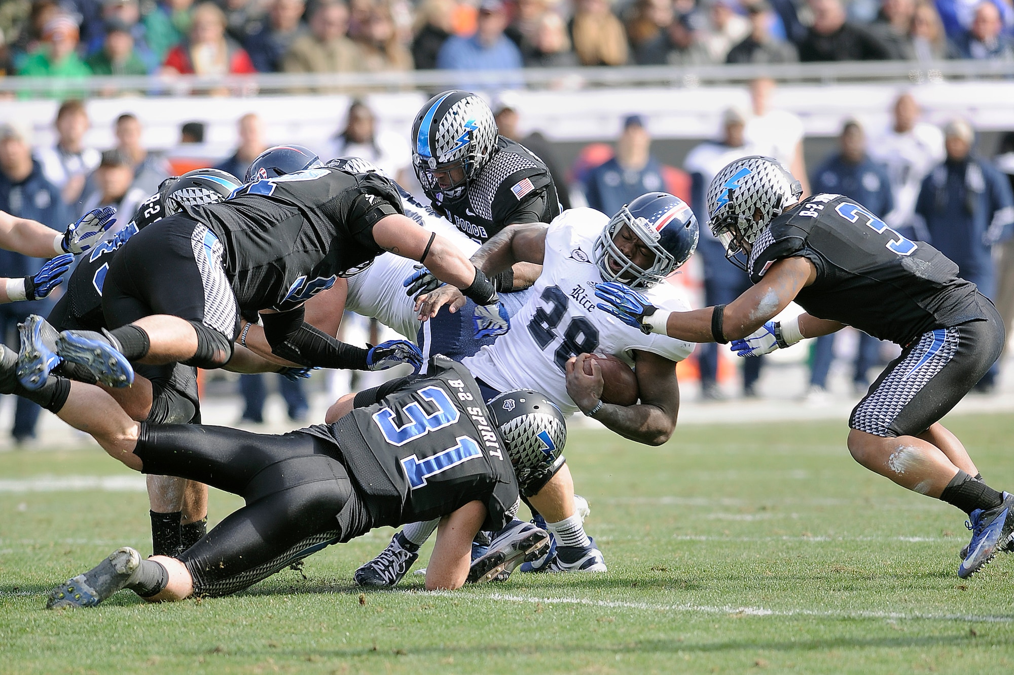 Rice running back Charles Ross is dragged down during the 2012 Armed Forces Bowl by a host of falcon defenders, including defensive backs Brian Lindsay, bottom, and Chris Miller, right. The bowl game was held December 28 in Ft. Worth, Texas.  
(U.S. Air Force photo/Sarah Chambers)
