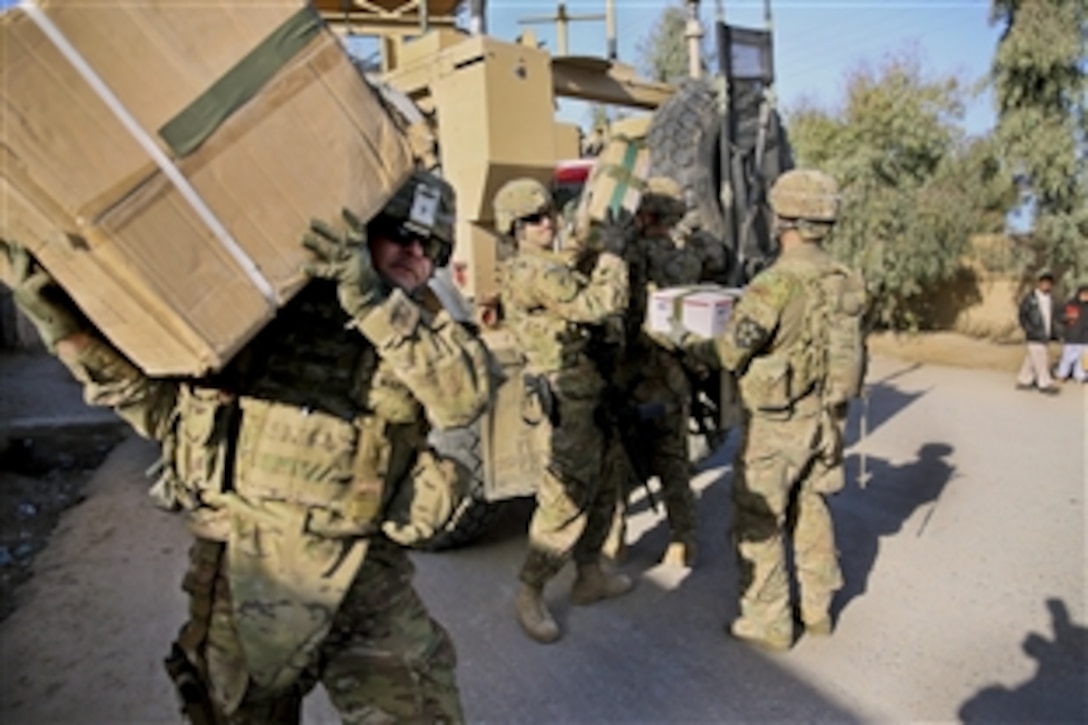 U.S. Army Lt. Col. Mark Martin, left, carries a box of school supplies while Spc. Vancil Casebolt, center, unloads additional boxes during a meeting with key leaders in Farah City, Afghanistan, Dec. 29, 2012. Martin is the civil affairs team lead and Casebolt is a team member for Provincial Reconstruction Team Farah.  The overall team's mission is to train, advise and assist Afghan government leaders at the municipal, district and provincial levels in the province.