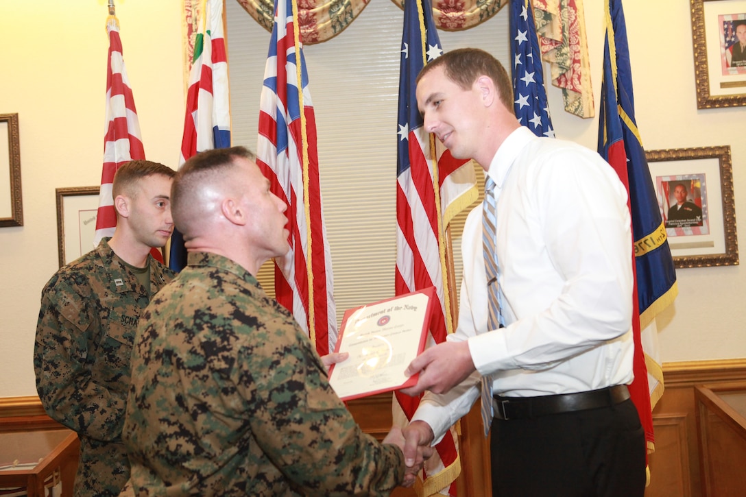 Col. Daniel J. Lecce, commanding officer of Marine Corps Base Camp Lejeune awarded David L. Swinney, an administrative support specialist with S-4, Headquarters and Support Battalion, Marine Corps Base Camp Lejeune, with the Meritorious Civilian Service Award during the ceremony held in building 1 aboard MCB Camp Lejeune, Feb. 1. Swinney competed with nearly 4,000 civilian employees to earn the award.