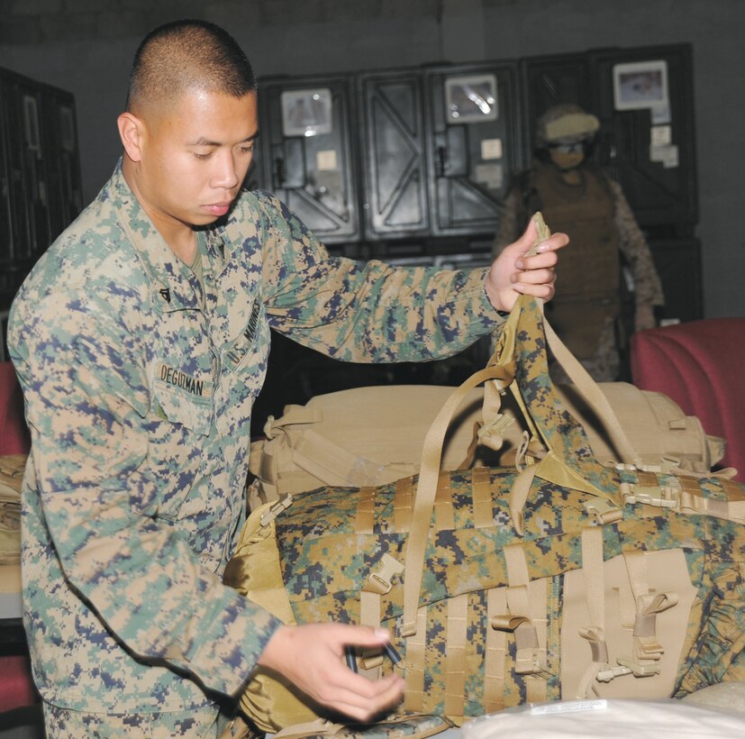 Cpl. Ghiemar DeGuzman adjusts his pack, one of many equipment items, for an upcoming overseas deployment.