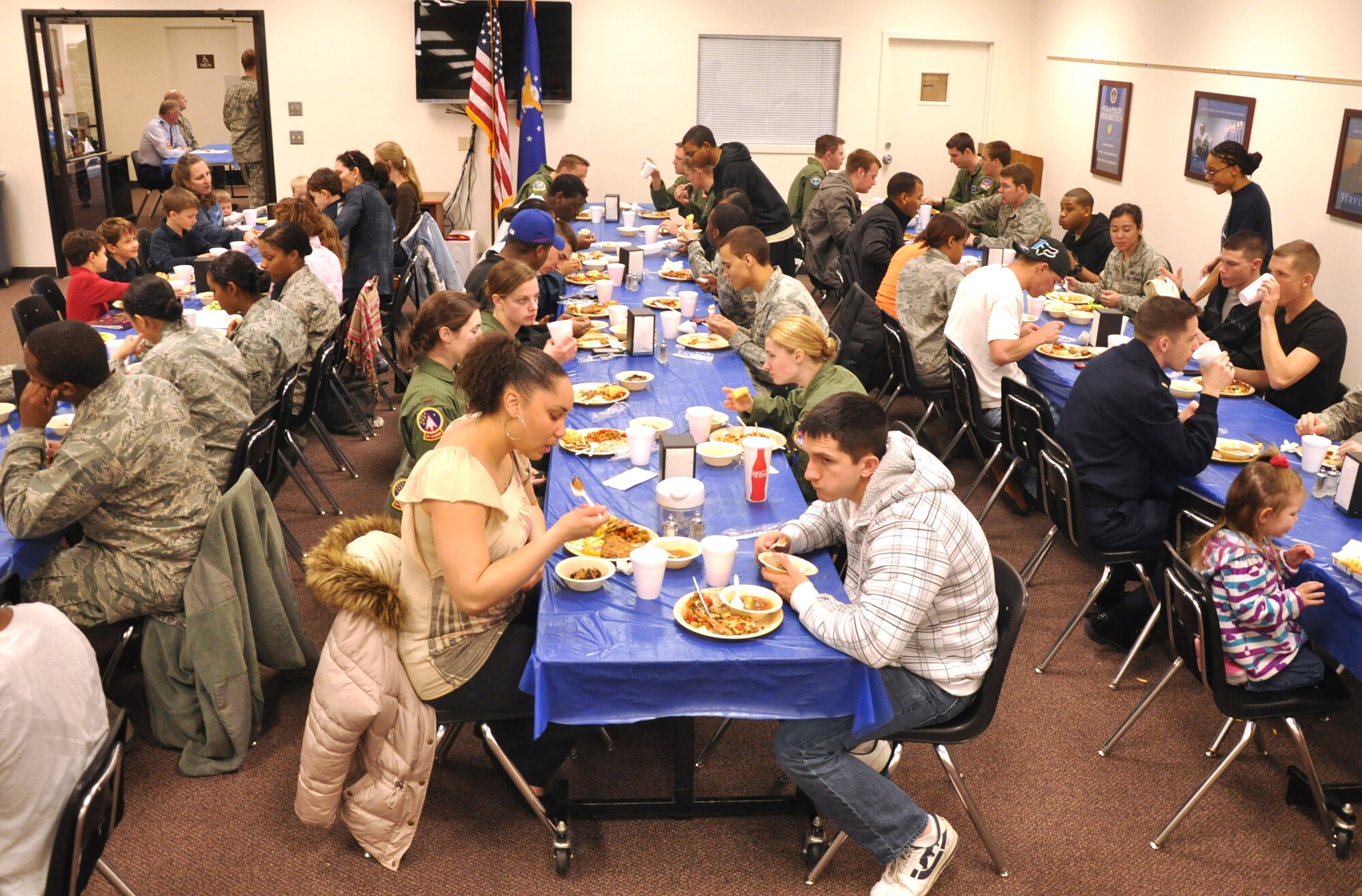 Single Airmen and family members of deployed Airmen at Vance Air Force Base, Okla., share a free dinner during the monthly Singles’ International Gourmet Meal Opportunity at the Community Chapel Activity Center, Jan. 30. The meal, provided by 25 volunteers from the 71st Mission Support Group this month, was attended by approximately 220. Vegetable pizza, cheddar cheese biscuits, salad and chicken breasts and various desserts were on this month’s menu. (U.S. Air Force photo/ Airman 1st Class Frank John Casciotta) 
