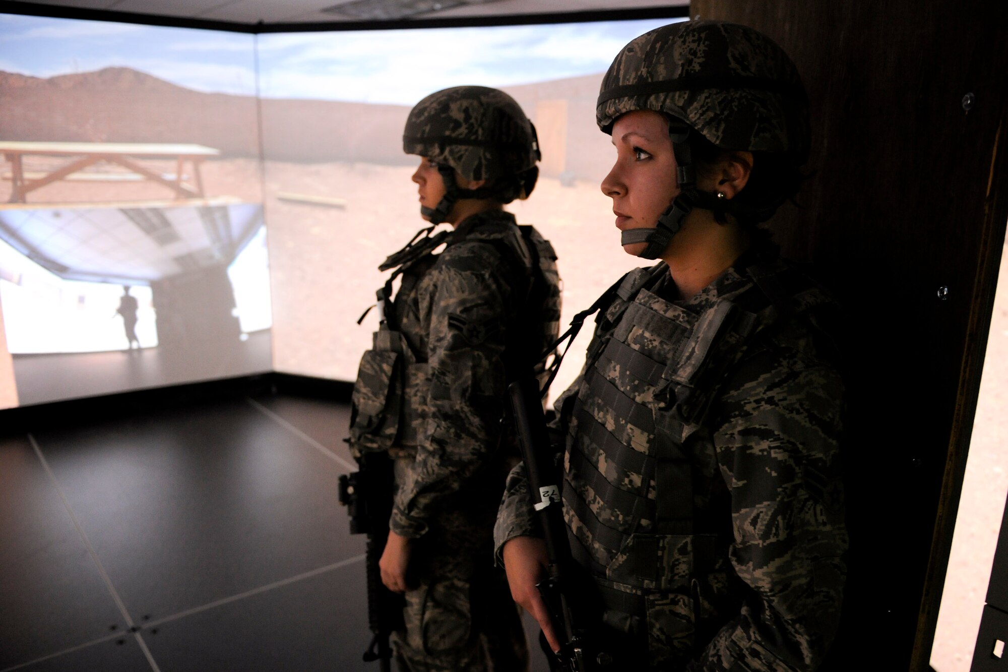 VANDENBERG AIR FORCE BASE, Calif. - Airman 1st Class Emily Groth and Airman 1st Class Molly Shortt, both 30th Security Forces Squadron members, review a combat scenario they just completed in the firearms training simulator at the Combat Arms Training Complex (Building 21308) here Friday, Jan. 27, 2012. The new simulator provides a virtual training environment for Vandenberg members to practice real-world combat tactics and scenarios based on Air Force qualification courses. (U.S. Air Force/Staff Sgt. Levi Riendeau)

