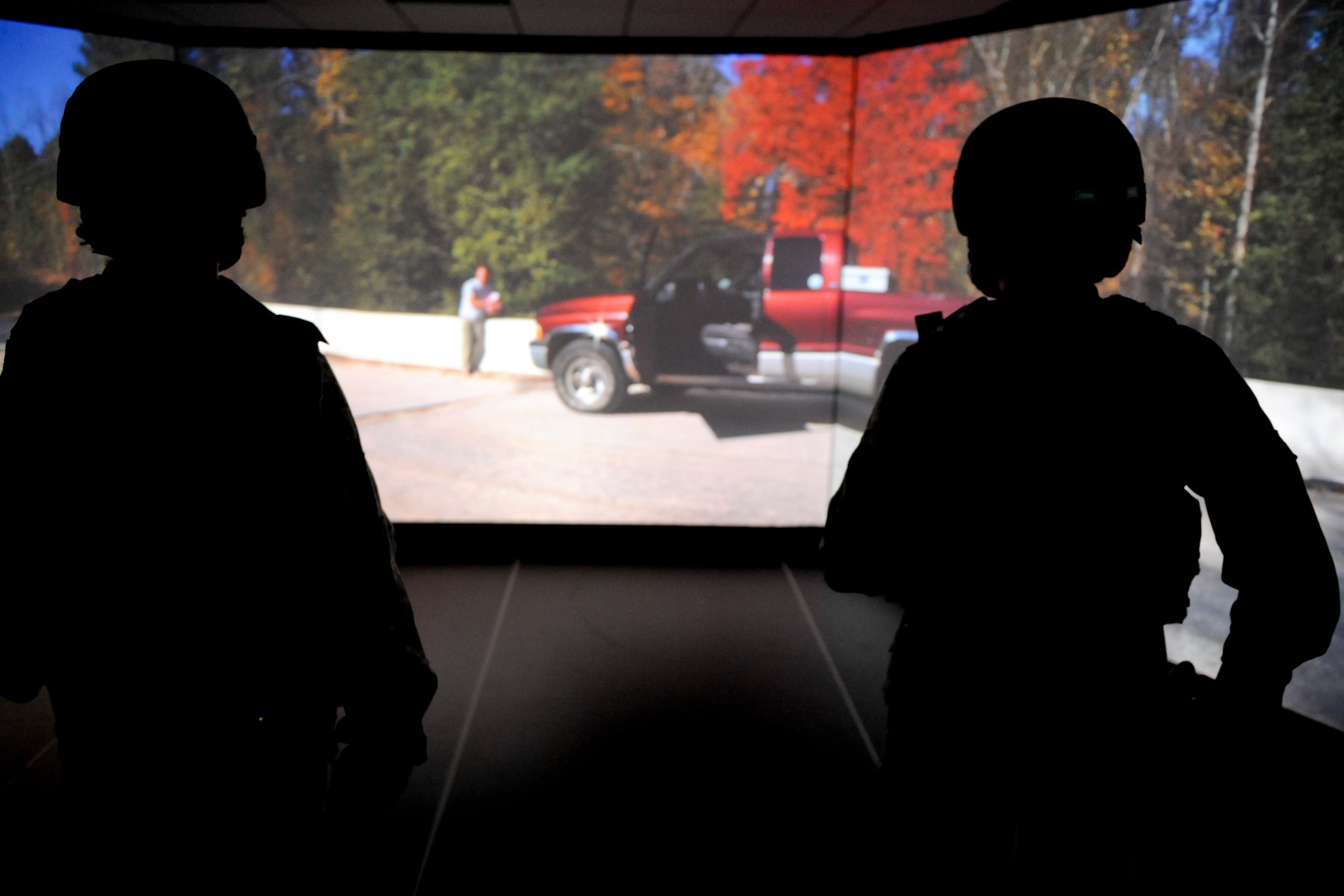VANDENBERG AIR FORCE BASE, Calif. - Airmen from the 30th Security Forces Squadron talk down an aggressive suspect during a scenario in the firearms training simulator at the Combat Arms Training Complex (Building 21308) here Friday, Jan. 27, 2012. The new simulator provides a virtual training environment for Vandenberg members to practice real-world combat tactics and scenarios based on Air Force qualification courses. (U.S. Air Force/Staff Sgt. Levi Riendeau)

