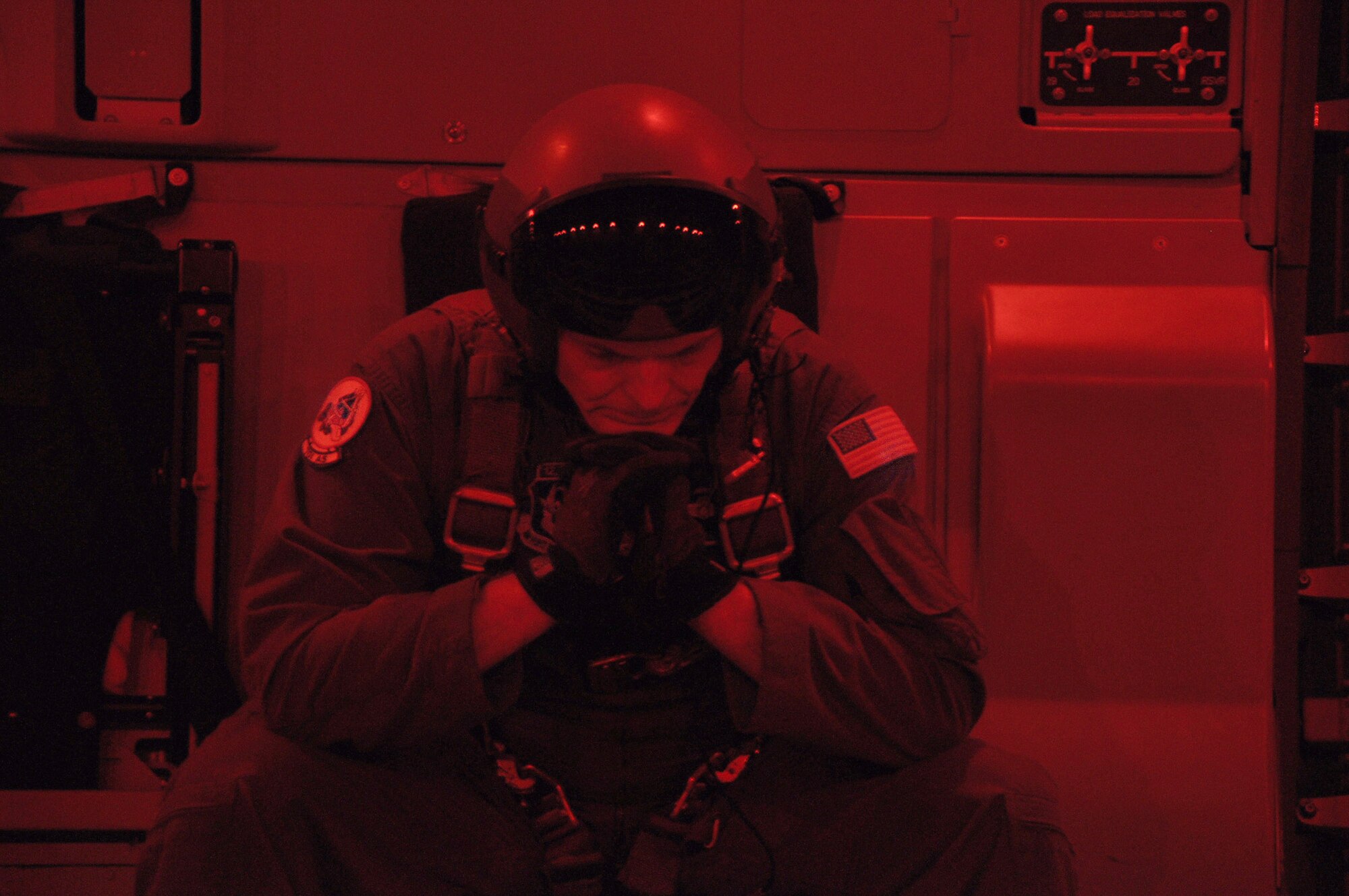 Senior Master Sgt. Benjamin E. Alexander, Jr., a loadmaster assigned to the 701st Airlift Squadron at Joint Base Charleston, S.C., sits idle moments before executing the release of cargo during the night air drop training mission aboard a C-17 Globemaster III aircraft January 31, 2012. (U.S. Air Force photo by Senior Airman Bobby Pilch)