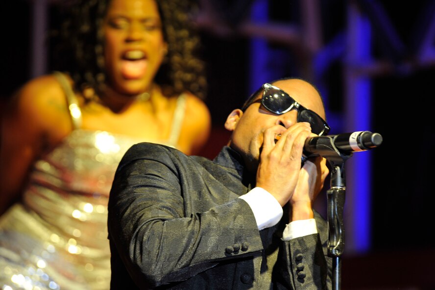 U.S. Air Force Staff Sgt. Derek Speights, Tops in Blue vocalist, plays the harmonica during a performance Jan. 31, 2012, Patriot Hall, Sumter, S.C. Tops in Blue is an Air Force special unit composed of 35 to 40 performers and technicians and is one of the oldest and most widely-traveled entertainment groups of its kind. (U.S. Air Force photo by Senior Airman Amber E. N. Jacobs/Released)