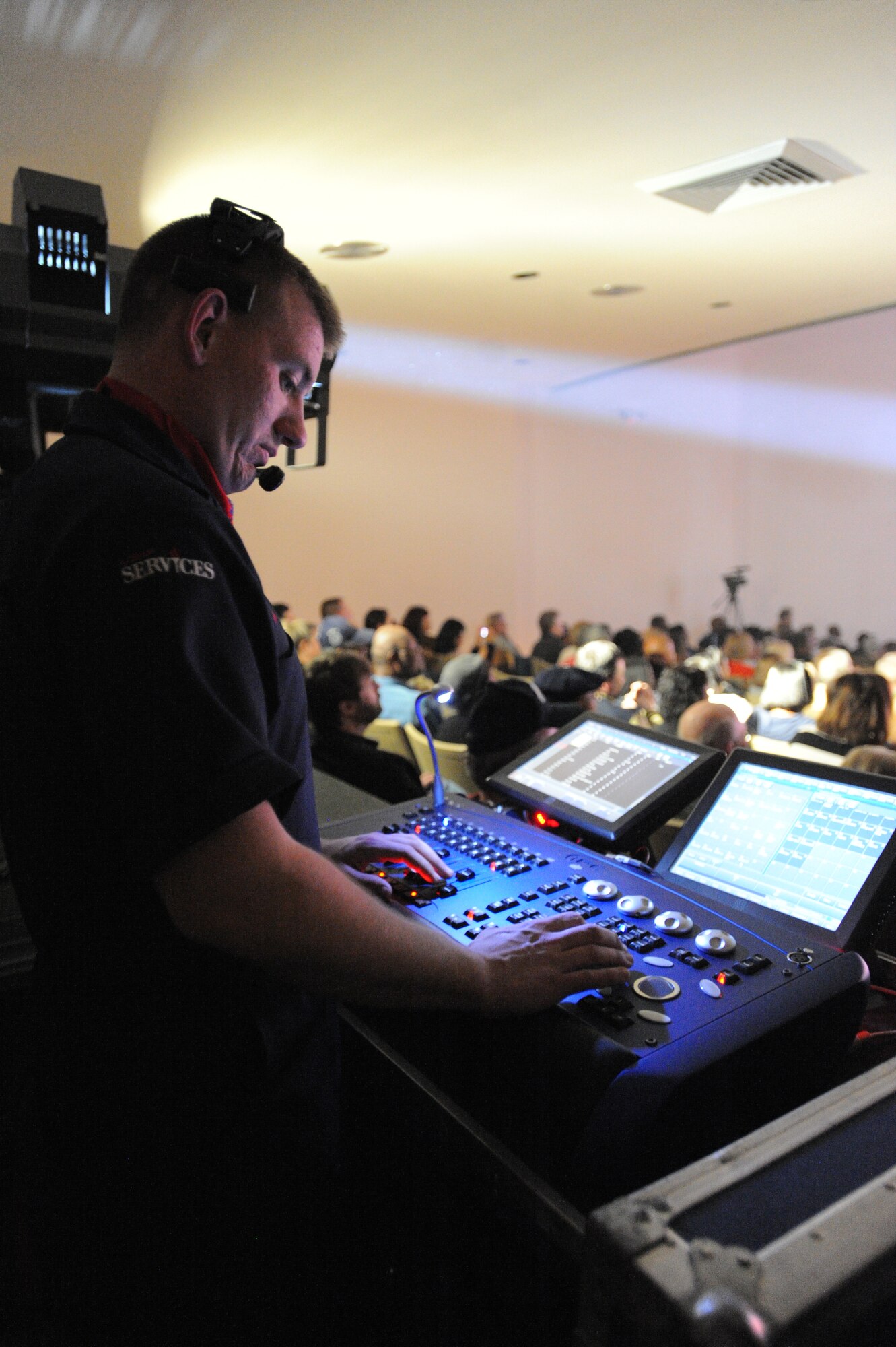 U.S. Air Force Airman 1st Class Kegan Davis, Tops in Blue lighting director, adjusts the lighting during a performance Jan. 31, 2012, Patriot Hall, Sumter, S.C. Davis is one of six technicians in charge of all of the equipment used during the show. (U.S. Air Force photo by Airman 1st Class Tabatha McCarthy/Released)