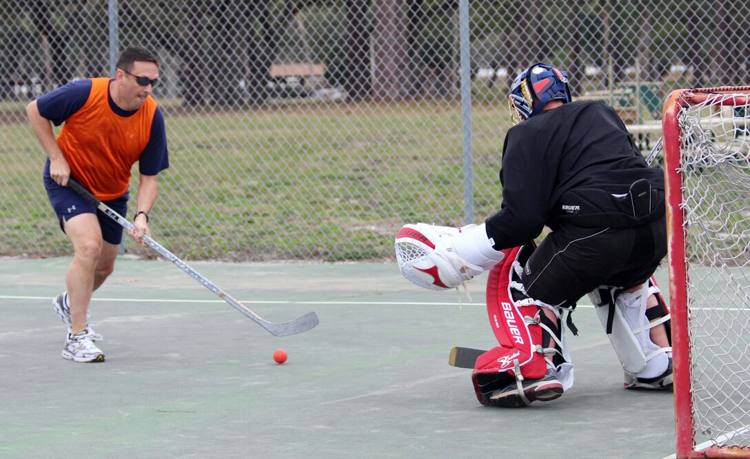 Tony Watson of the Tyndall Air Force Base Canadian Detachment team sets up for a shot against the goalie of the Royal Canadian Air Force’s 409 Squadron team during a game of street hockey Jan. 31. The 409 Squadron, which flies CF-18s, is at Tyndall to participate in Combat Archer training with the 53rd Weapons Evaluation Group. Given the rarity of visits by other Canadian units to Tyndall, the base detachment jumped on the chance to play a friendly game of their national sport with fellow Canadians. (U.S. Air Force photo by Angela Pope) 