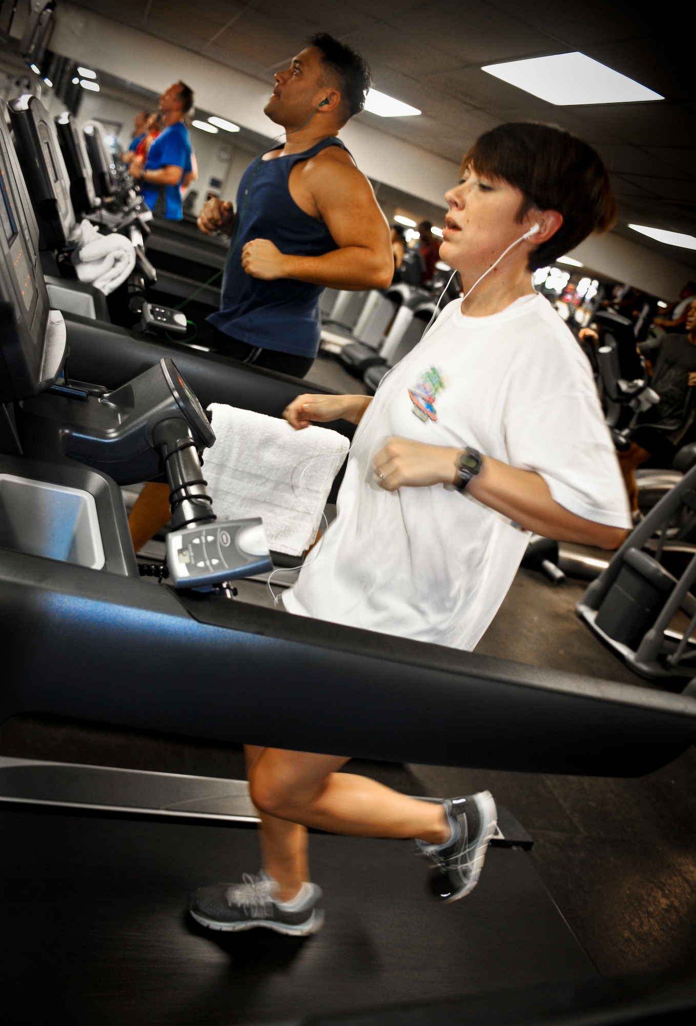 Capt. Laura Porter, chief of Combat Airspace Operations with the 613th Air and Space Operations Center runs on a treadmill at the Hickam gym, Jan. 27. Safety clarified a policy regarding headphones while exercising outdoors to ensure the safety of Airmen as they workout becuase wearing headphones lessens situational awareness. The only approved running routes that individuals can wear headphones on are the Missing Man Formation trail and the Earhart Field track. (U.S. Air Force photo/Senior Airman Lauren Main)