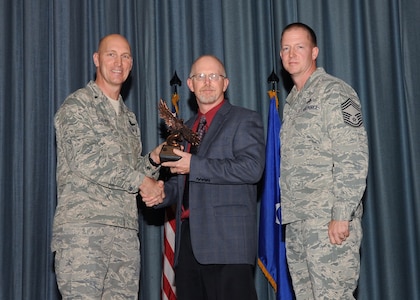 The fourth-quarter Joint Base San Antonio-Randolph award winners were recognized during an awards ceremony at the base theater Jan. 31.  Brig. Gen. Tim Zadalis, Air Education and Training Command director of intelligence, operations and nuclear integration, on left, and Chief Master Sgt. Charles Meyer, AETC chief of safety, right, present the Supervisor Civilian Category II of the Quarter Award to Paul Hughes from AETC.  (U.S. Air Force photo/Melissa Peterson)