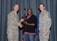 The fourth-quarter Joint Base San Antonio-Randolph award winners were recognized during an awards ceremony at the base theater Jan. 31.  Brig. Gen. Tim Zadalis, Air Education and Training Command director of intelligence, operations and nuclear integration, on left, and Chief Master Sgt. Charles Meyer, AETC chief of safety, right, present the Wage Civilian Grade of the Quarter Award to Vanessa Lazare from the 902nd Mission Support Group.  (U.S. Air Force photo/Melissa Peterson)