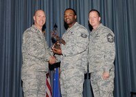 The fourth-quarter Joint Base San Antonio-Randolph award winners were recognized during an awards ceremony at the base theater Jan. 31.  Brig. Gen. Tim Zadalis, Air Education and Training Command director of intelligence, operations and nuclear integration, on left, and Chief Master Sgt. Charles Meyer, AETC chief of safety, right, present the Honor Guard NCO of the Quarter Award to Tech. Sgt. Mikal Dantley from the Air Force Personnel Center.  (U.S. Air Force photo/Melissa Peterson)