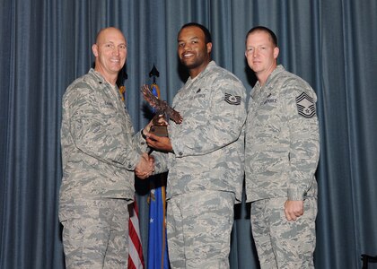 The fourth-quarter Joint Base San Antonio-Randolph award winners were recognized during an awards ceremony at the base theater Jan. 31.  Brig. Gen. Tim Zadalis, Air Education and Training Command director of intelligence, operations and nuclear integration, on left, and Chief Master Sgt. Charles Meyer, AETC chief of safety, right, present the Honor Guard NCO of the Quarter Award to Tech. Sgt. Mikal Dantley from the Air Force Personnel Center.  (U.S. Air Force photo/Melissa Peterson)