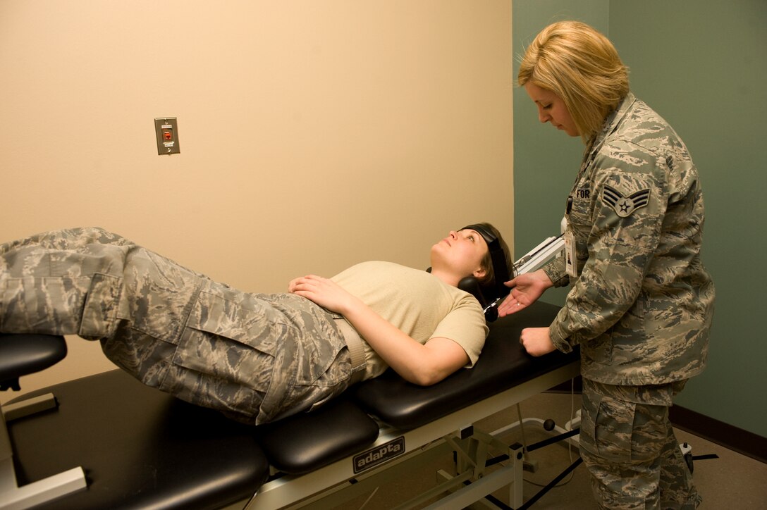 Senior Airman Haylley Carlson, 28th Medical Operations Squadron physical therapy technician, ensures Staff Sgt. Janet Schreiber, 28th Maintenance Squardon aircraft structural maintainer, is placed properly in the cervical traction machine at the physcial therapy center on Ellsworth Air Force Base, S.D., Jan. 26, 2012.  The cervical traction machine helps to alleviate pain without surgery by spreading a patient’s vertebrae apart.  (U.S. Air Force photo by Airman 1st Class Anania Tekurio)