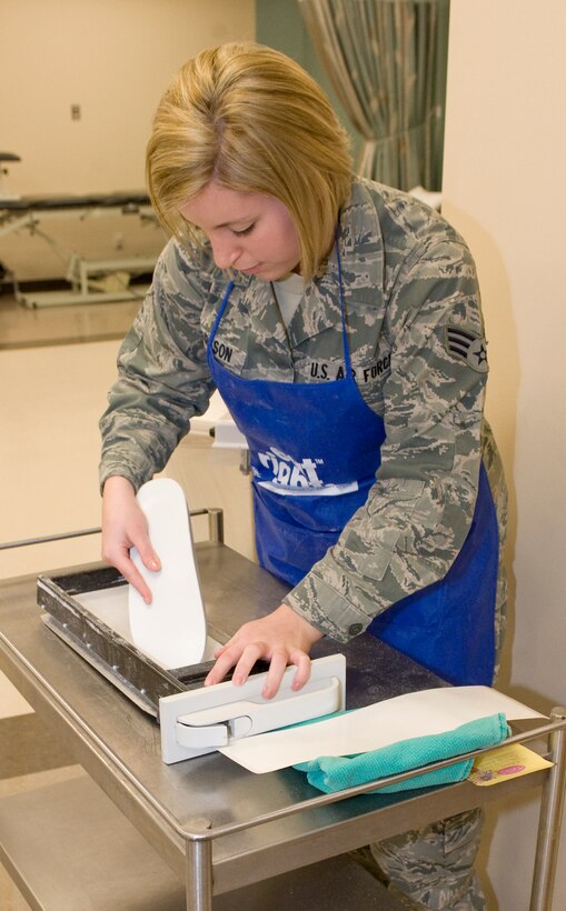 Senior Airman Haylley Carlson, 28th Medical Operations Squadron physical therapy technician, places a foot insole into the Amfit Insole Fabrication System at the physical therapy center on Ellsworth Air Force Base, S.D., Jan. 26, 2012.  The physical therapy center is one of few in the Air Force that provides orthotics production as a custom alternative option.  (U.S. Air Force photo by Airman 1st Class Anania Tekurio/Released) 