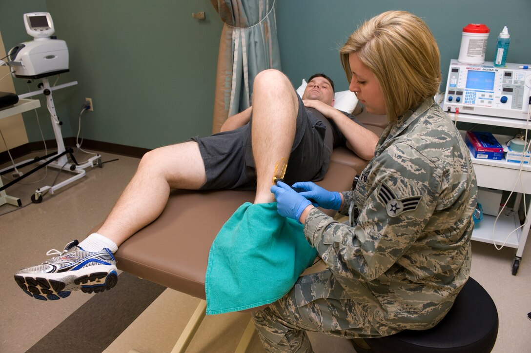 Senior Airman Haylley Carlson, 28th Medical Operations Squadron physical therapy technician, treats Tech. Sgt. Matthew Huddle, Air Force Financial Services Center team chief Air Force Reserve Command Travel, with soft tissue mobilization therapy at the physical therapy center on Ellsworth Air Force Base, S.D., Jan. 26, 2012.  The soft tissue mobilization therapy breaks up scar tissue to allow for pain relief.  (U.S. Air Force photo by Airman 1st Class Anania Tekurio/Released)
