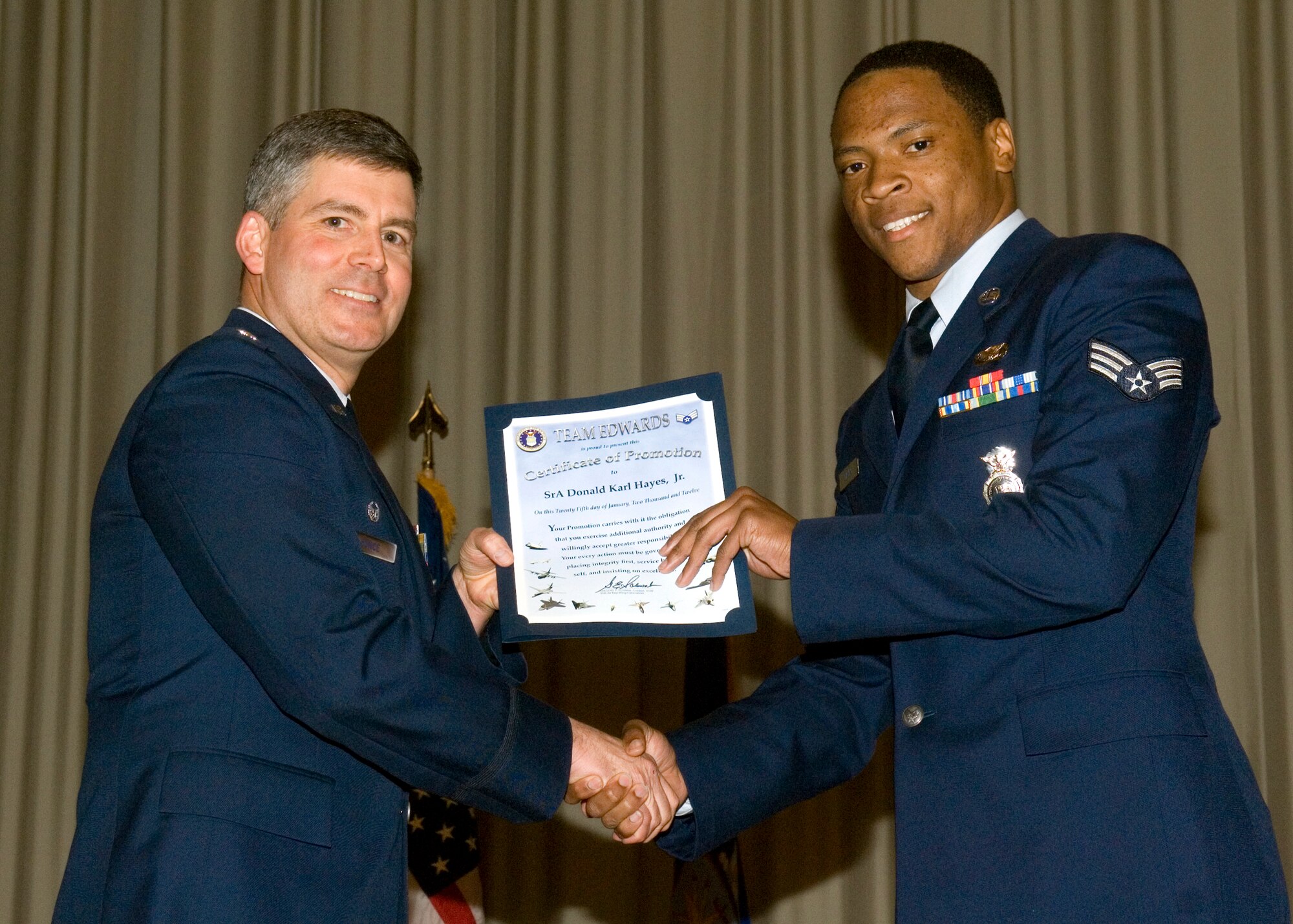 Airman 1st Class Donald Hayes, Jr., 95th Security Forces Squadron, gets promoted to senior airman with the help of Lt. Col. Leon Yonce, 95th SFS commander, Jan. 31 in the Base Theater. Both January and February promotees were honored during the ceremony. (U.S. Air Force photo by Rob Densmore)