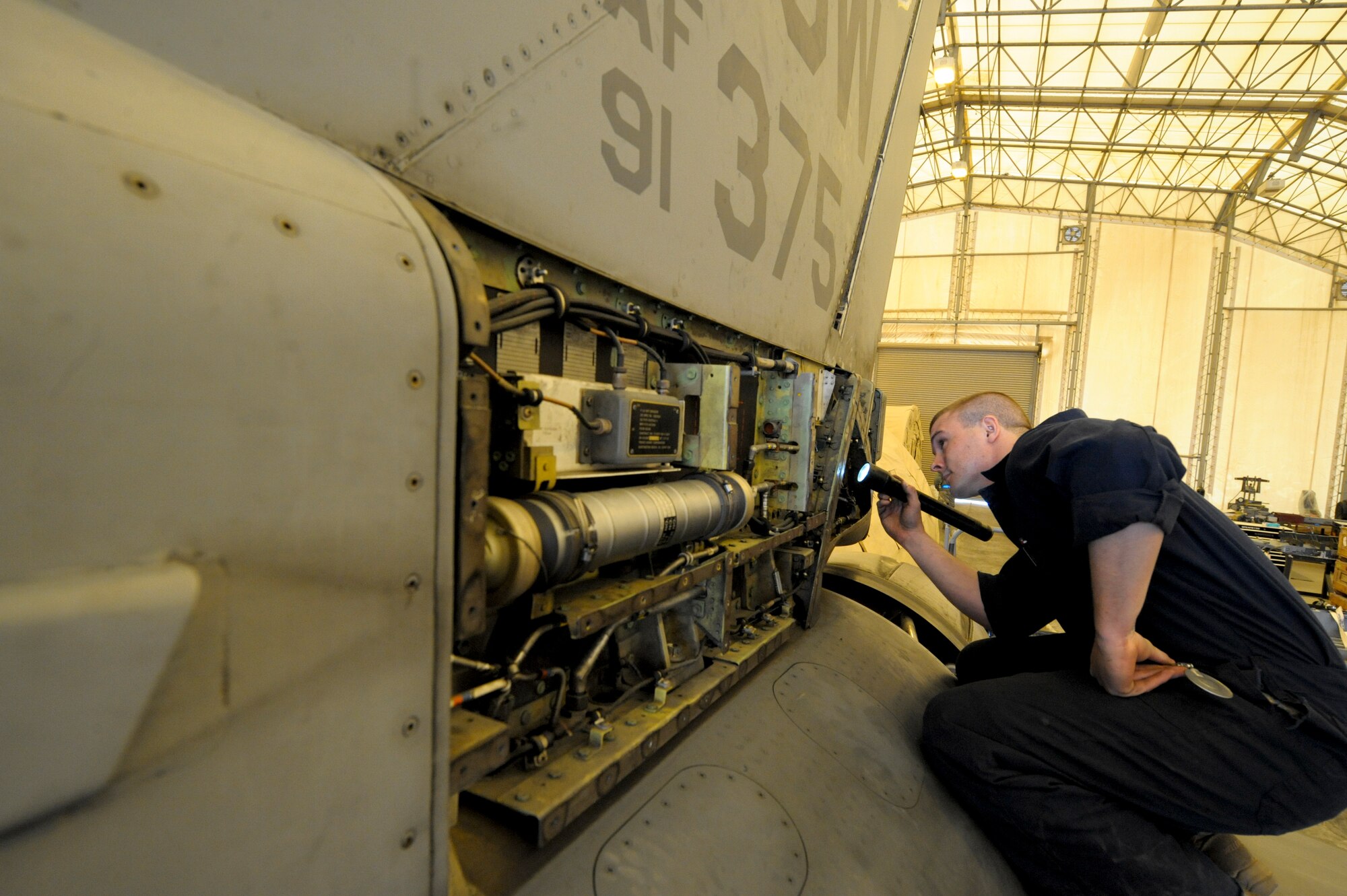 Staff Sgt. James Nunn, 332nd Expeditionary Maintenance Squadron crew chief, inspects the flight control accumulators during a phase inspection on an F-16 Fighting Falcon at an undisclosed location in Southwest Asia, Jan. 31, 2012. The accumulators aid in adjusting flight controls during flight. Nunn is deployed from Shaw Air Force Base, S.C. and is a native of Wilmington, N.C. (U.S. Air Force photo by Staff Sgt. Joshua J. Garcia/Released)