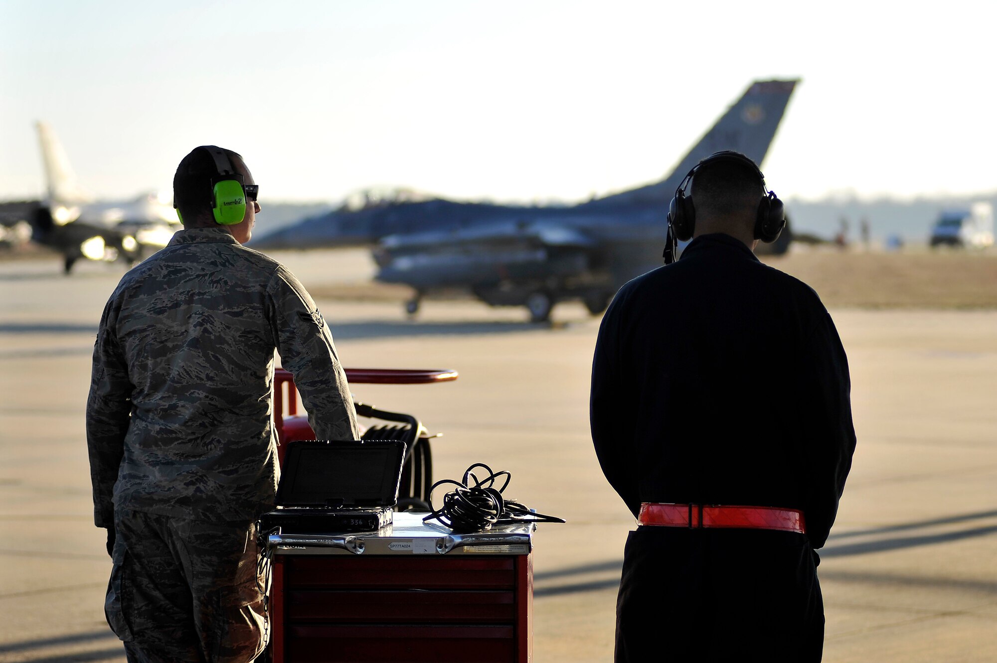 U.S. Air Force crew chiefs with the 77th Fighter Squadron watch as several F-16 Fighting Falcons taxi onto the Shaw runway after being prepped and launched during an Operational Readiness Exercise, Jan. 31, 2012, Shaw Air Force Base, S.C. The ORE evaluated the 20th Fighter Wing's ability to meet wartime and contingency tasks. During this particular exercise, 77th FS personnel prepped and launched several F-16s to challenge and enhance their wartime capabilities. (U.S. Air Force photo by Senior Airman Kenny Holston/Released)

