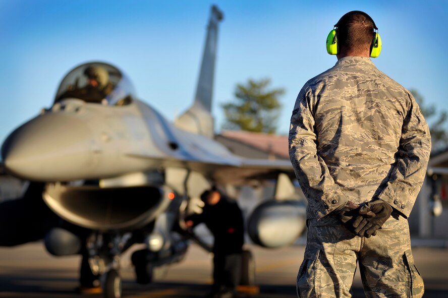 U.S. Air Force Airman 1st Class Ronald Batchelor, 77th Fighter Squadron weapons crew member, stands by while crew chiefs prep an F-16 Fighting Falcon to be launched during an Operational Readiness Exercise, Jan. 31, 2012, Shaw Air Force Base, S.C. The ORE evaluated the 20th Fighter Wing's ability to meet wartime and contingency tasks. During this particular exercise, 77th FS personnel prepped and launched several F-16s to challenge and enhance their wartime capabilities. (U.S. Air Force photo by Senior Airman Kenny Holston/Released)

